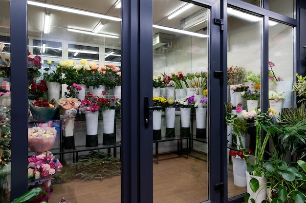 Vitrine d'un fleuriste vendant des fleurs naturelles avec des bouquets au réfrigérateur dans des vases