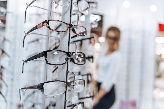 Vitrine avec lunettes en magasin ophtalmique moderne. Boutique de lunettes. Tenez-vous avec des lunettes dans le magasin d'optique. Vitrine avec lunettes en magasin ophtalmique moderne. Fermer.