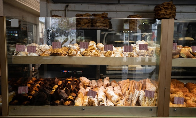 vitrine d'un magasin de pâtisserie vendant des gâteaux et des tartes de cannoli au dessert avec des étiquettes de prix à travers la fenêtre en verre de l'affichage beaucoup de pâtisseries dans le magasin