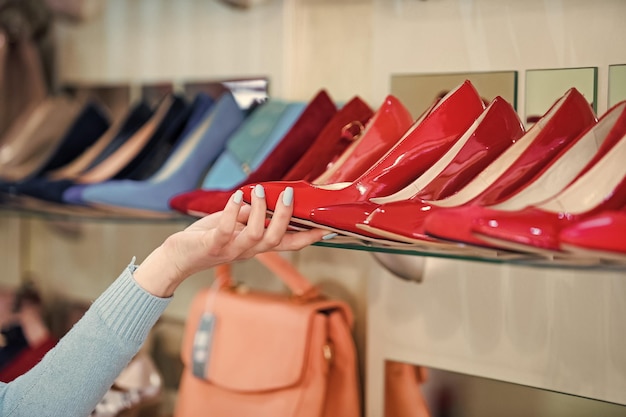 Photo vitrine de magasinage avec chaussures féminines et main