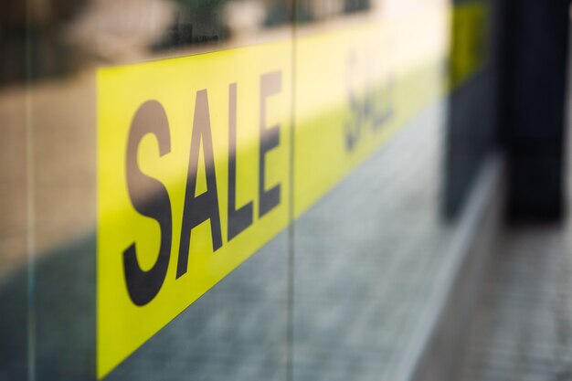 Vitrine avec panneau de vente jaune. Shopping, concept de réduction