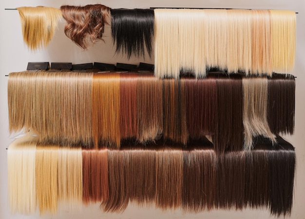 Vitrine de perruques d'aspect naturel de différentes couleurs dans un salon de beauté nuances de cheveux sur une étagère dans un magasin de perruques