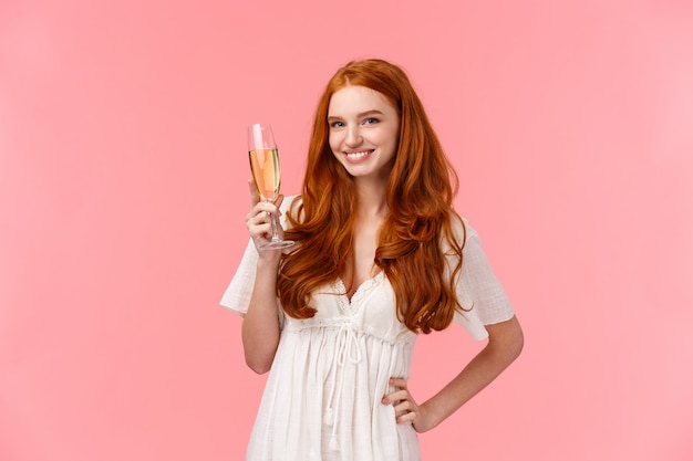 Vive notre succès. Belle et confiante femme rousse levant le verre et prononçant un discours