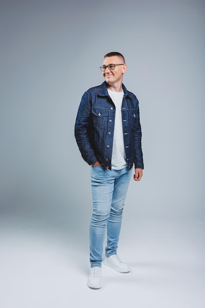 Vivez une vie riche Émotions positives Portrait d'un jeune homme séduisant vêtu d'un t-shirt blanc et d'une veste en jean Vêtements pour hommes de la collection denim