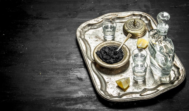 Vodka au caviar sur l'ancien plateau. Sur un tableau noir.