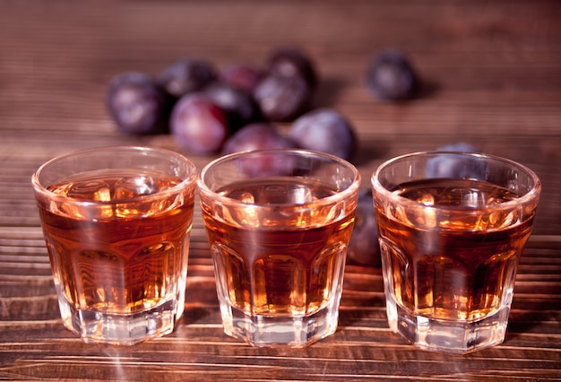 Vodka aux prunes ou brandy aux prunes fraîches sur table en bois.