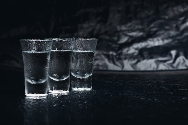 Vodka. Coups, verres de vodka avec de la glace. Fond sombre. Espace de copie .Mise au point sélective