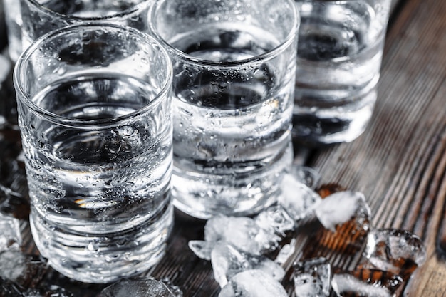 Vodka dans des verres à liqueur sur bois rustique