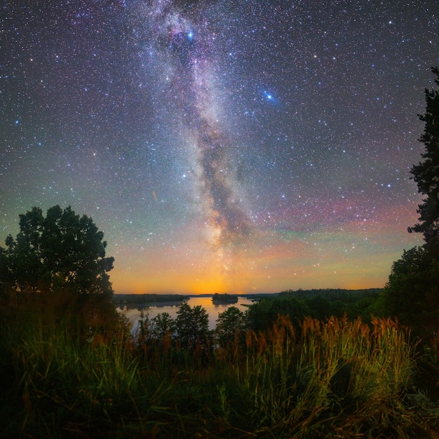 Voie lactée lumineuse sur le lac, photo de nuit