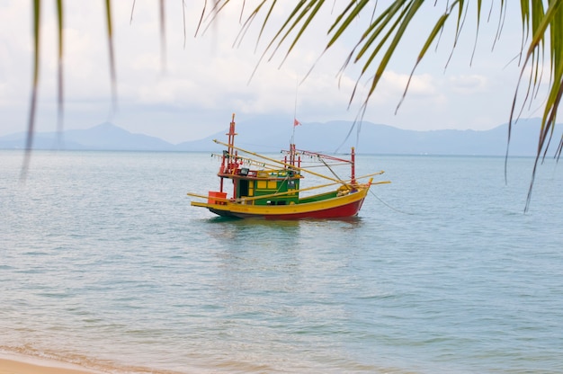 Voile bateau de pêche coloré dans l'eau de mer, bateau multicolore dans l'océan tropical peu profond. Thaïlande