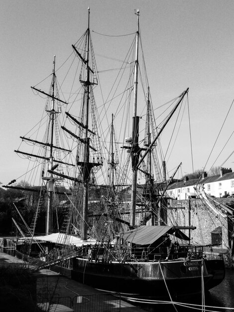 Photo un voilier amarré au port contre un ciel dégagé.