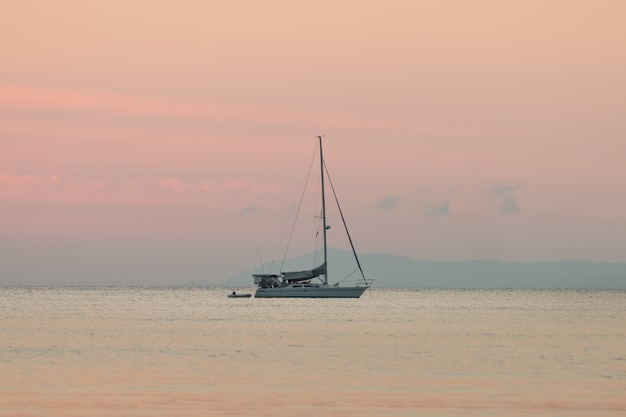 Voilier dans la mer de fond de l'été et le coucher du soleil dans la soirée.