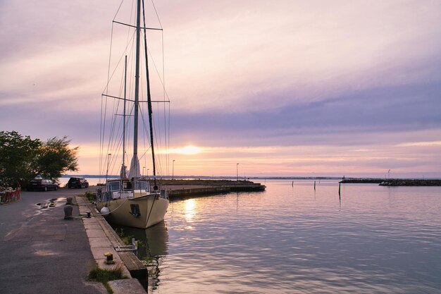 Voilier dans le port du lac Vaettern au coucher du soleil Phare en arrière-plan