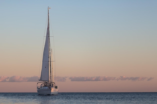 Un voilier sur la mer contre le ciel au coucher du soleil