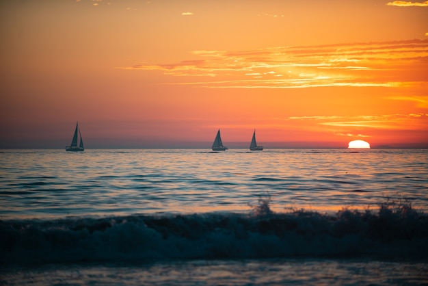 Voilier en mer vue panoramique du coucher de soleil sur l'océan belle scène sereine mer ciel concept lever du soleil c...