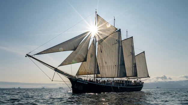 un voilier avec le soleil brillant sur le dessus