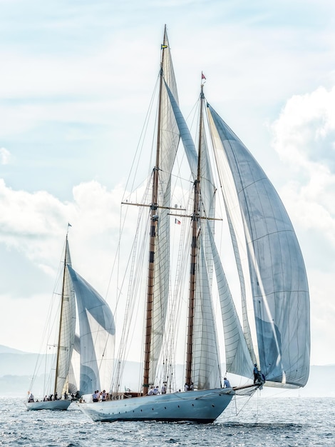 Des voiliers naviguant en mer contre le ciel