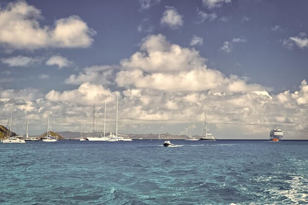 Voiliers navire et bateau naviguant dans la mer bleue sur ciel nuageux à gustavia stbarts Aventure de voile et de plaisance Vacances d'été sur une île tropicale Transport par eau et navires marins