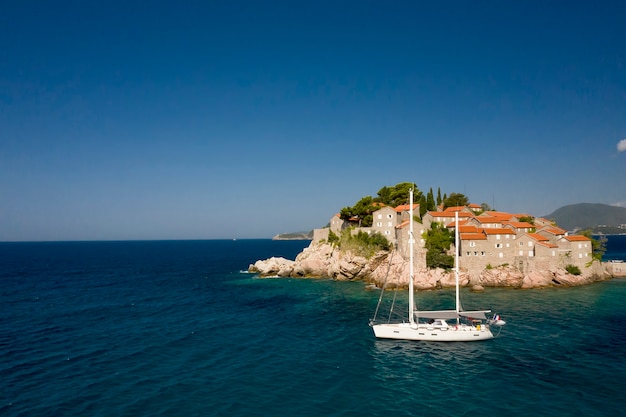 Voir au bateau passant par l'îlot de Sveti Stefan au Monténégro