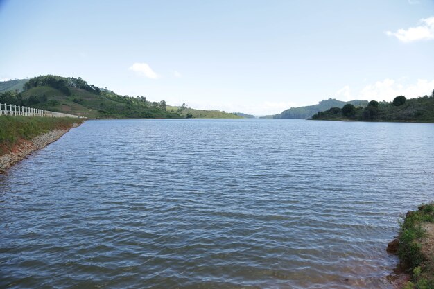 Voir le barrage avec le pêcheur avec beaucoup de soleil d'été brésilien tropical et la natation de chien