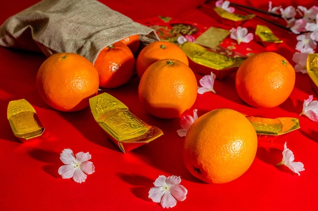 Voir ci-dessus les accessoires du nouvel an chinois ou les oranges du festival Mood day or et les poches Angpao avec des décorations de branches de fleurs de cerisier.