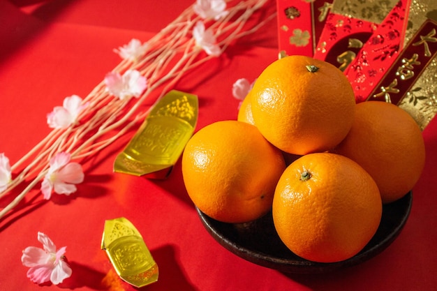 Voir ci-dessus les accessoires du nouvel an chinois ou les oranges du festival Mood day or et les poches Angpao avec des décorations de branches de fleurs de cerisier.