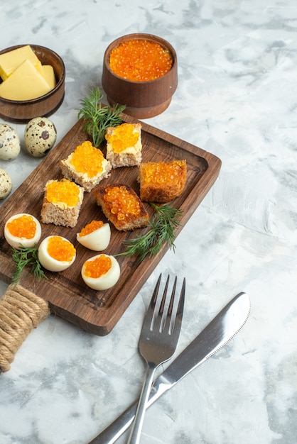 Voir ci-dessus de délicieux sandwichs au caviar avec des œufs durs sur une planche à découper surface blanche petit déjeuner fruits de mer déjeuner nourriture pain grillé repas poisson