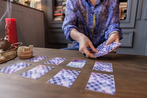 Voir le destin. Gros plan sur des cartes de tarot entre des mains de femmes tout en ayant une séance de voyance