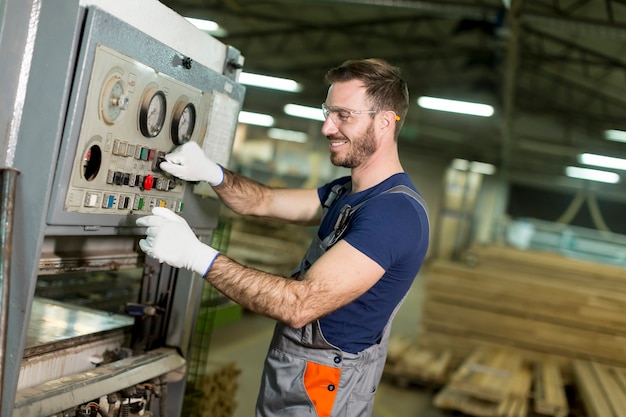 Voir à jeune homme travaille dans une usine pour la production de meubles
