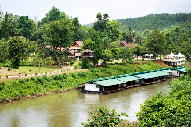 Voir le paysage et la maison de radeau flotter sur la rivière si sawat ou khwae kwai avec la forêt de montagne du col du feu de l'enfer dans le parc national de la cascade de Sai Yok pour une visite de voyage à la grotte de Tham krasae à Kanchanaburi en Thaïlande