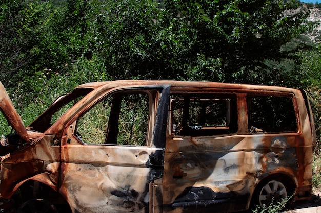 Voiture abandonnée et incendiée au milieu de la forêt