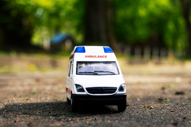 Voiture d'ambulance sur l'asphalte parmi les arbres