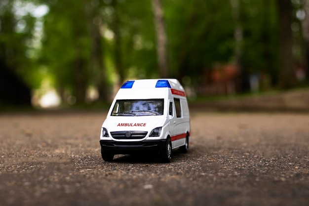 Voiture d'ambulance sur l'asphalte parmi les arbres