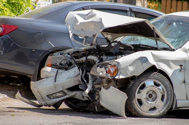 Voiture blanche accidentée sur la route Accident de la route cassé devant le capot tordu de la voiture et pare-brise cassé