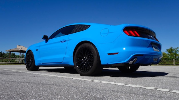 Une voiture bleue sur la route contre le ciel