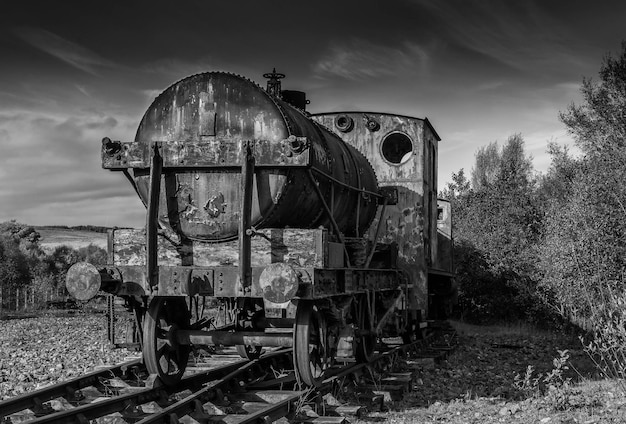 Photo voiture de chemin de fer abandonnée sur le champ contre le ciel