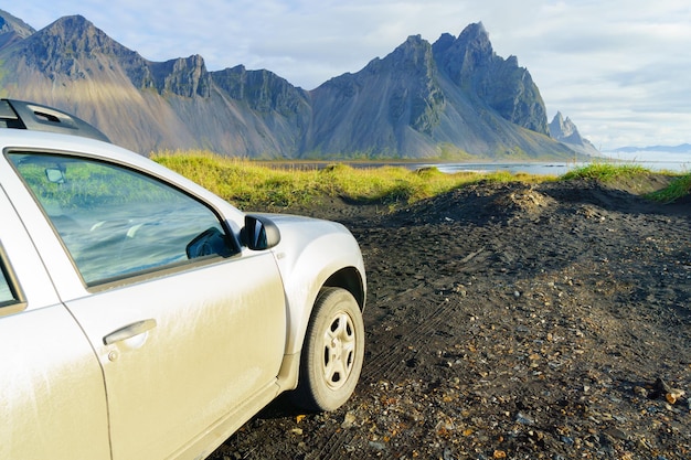 Voiture de couleur argent sale sur route de campagne à Vesturhorn Mountain en matin d'été. Stokksnes, Islande, Europe du Nord, Scandinavie. Magnifique paysage naturel pittoresque. Attraction touristique populaire.