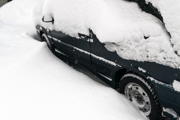 Voiture couverte de neige après un blizzard hivernal