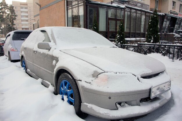 Voiture couverte de neige depuis longtemps dans la rue