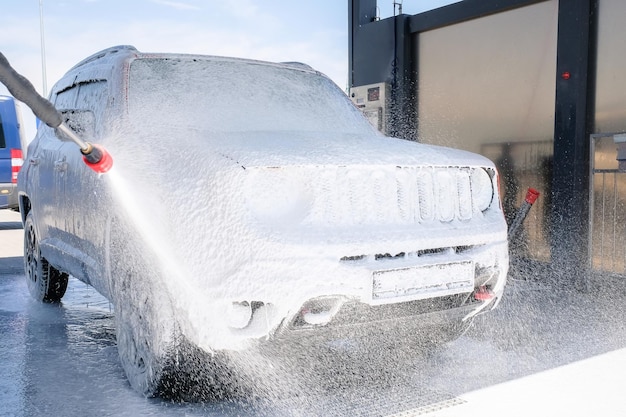 Voiture dans la mousse au lave-auto Lave-auto manuel