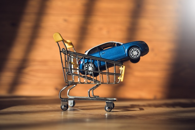 Voiture dans un panier sur un fond en bois