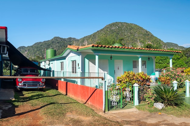 Voiture d'époque à l'ancienne par la maison colorée d'été contre les montagnes de la ville de Vinales, Cuba.