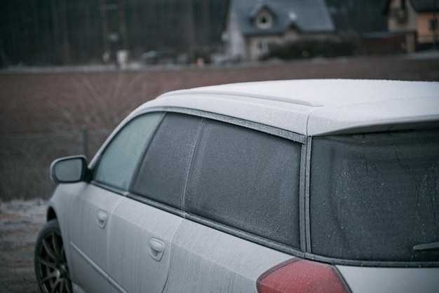 La voiture est couverte de givre le matin froid avec un véhicule garé à l'extérieur pendant la nuit