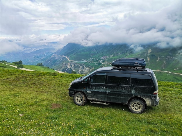 Une voiture sur le fond de belles montagnes verdoyantes au Daghestan avec des nuages Russie