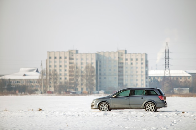 Voiture garée dans un champ enneigé le jour de l'hiver.