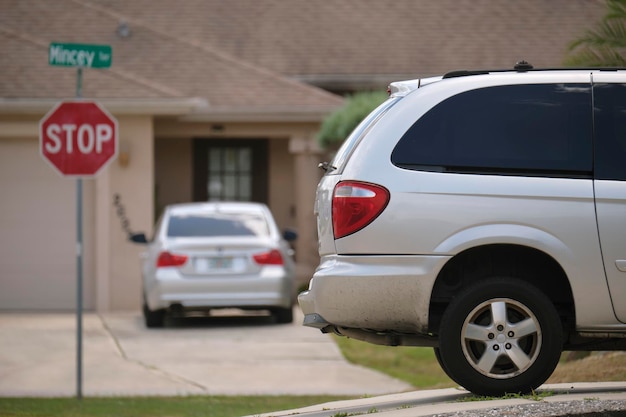 Voiture garée devant une large porte double de garage sur une allée en béton d'une nouvelle maison américaine moderne