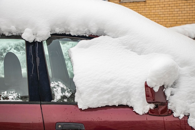 Voiture gelée enneigée recouverte de neige Route d'hiver Danger de conduite hivernale Déneigement de voiture Situation de circulation dangereuse