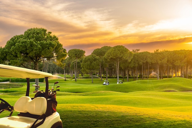 Voiture de golf sur un parcours de golf au coucher du soleil en Turquie Belek