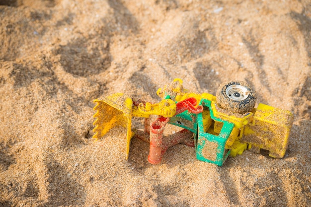 Voiture jouet colorée sur le fond de la plage de sable