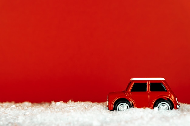 Voiture jouet rétro rouge sur une route enneigée sur salle rouge